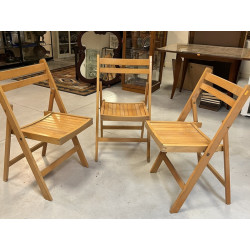 Trois chaises pliantes en bois clair
